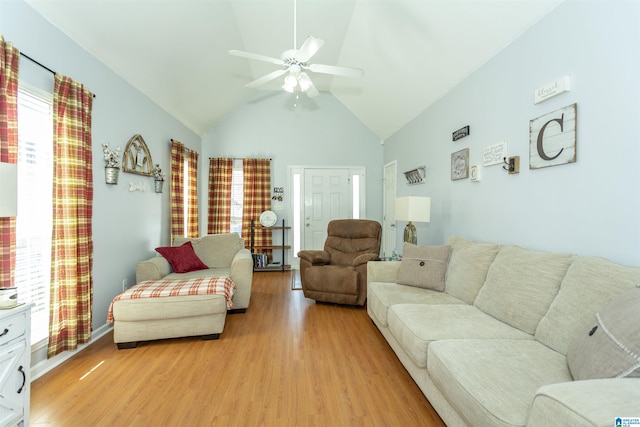 living room with high vaulted ceiling, a wealth of natural light, ceiling fan, and light hardwood / wood-style flooring