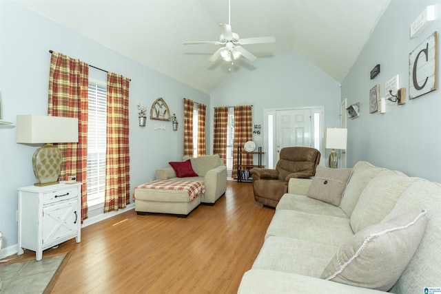 living room with ceiling fan, high vaulted ceiling, and light wood-type flooring