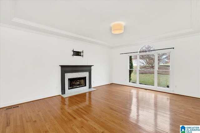 unfurnished living room featuring hardwood / wood-style floors, crown molding, and a high end fireplace