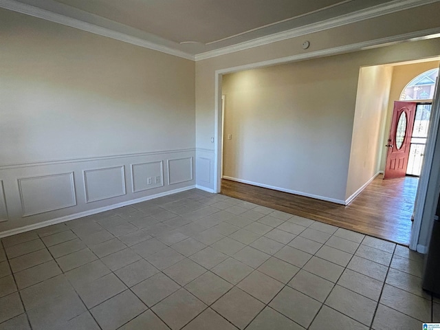 empty room featuring crown molding and light tile patterned floors