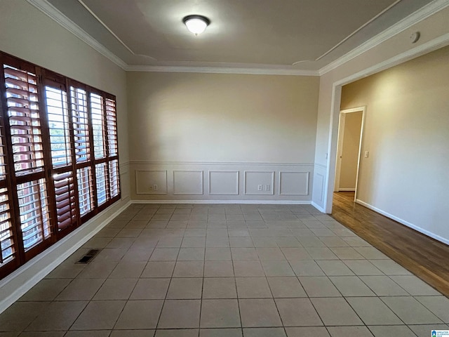 spare room featuring ornamental molding and light tile patterned flooring