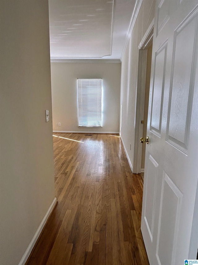 corridor with hardwood / wood-style flooring and ornamental molding