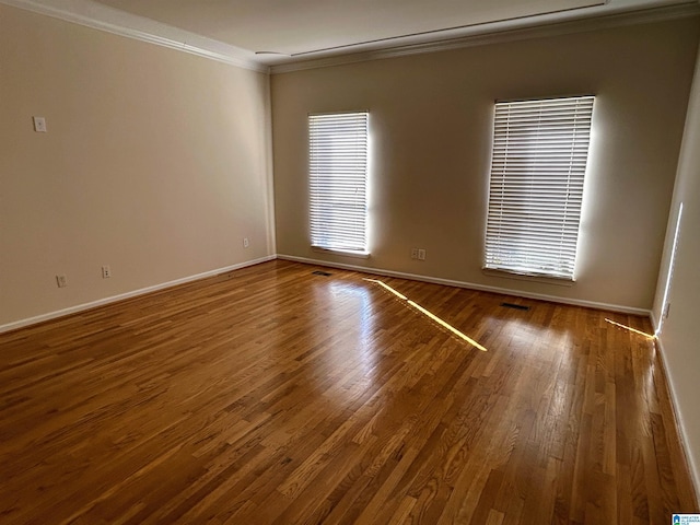 empty room with hardwood / wood-style flooring and ornamental molding