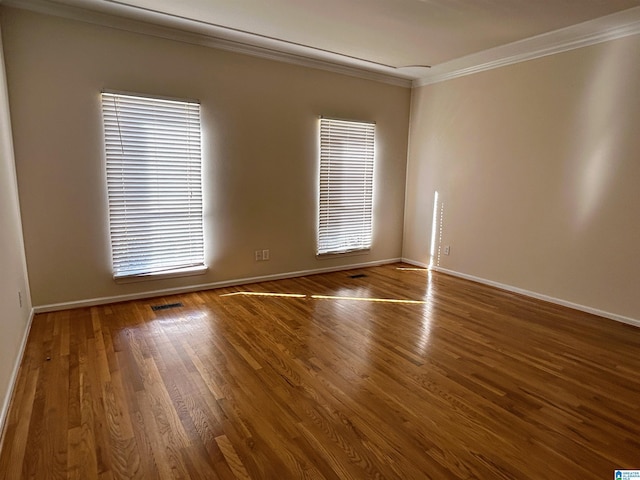 spare room with ornamental molding and hardwood / wood-style floors