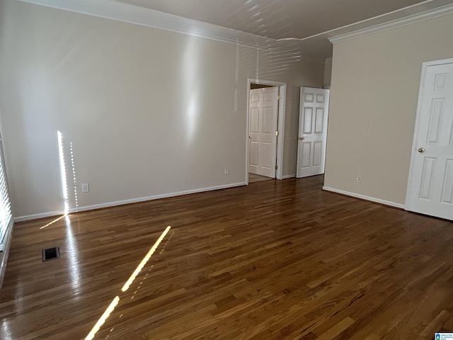 empty room featuring ornamental molding and dark hardwood / wood-style floors