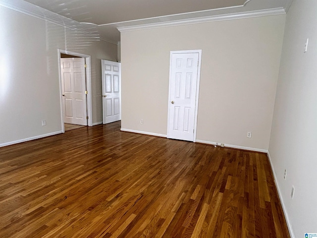 spare room featuring dark wood-type flooring and ornamental molding