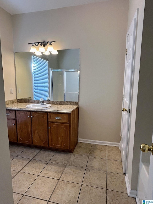 bathroom featuring tile patterned flooring, vanity, and a shower with shower door