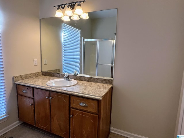 bathroom with tile patterned flooring, vanity, a chandelier, and walk in shower