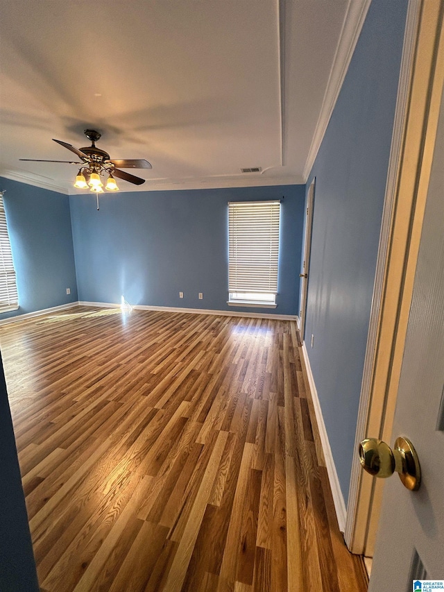 spare room featuring crown molding, dark hardwood / wood-style floors, and ceiling fan