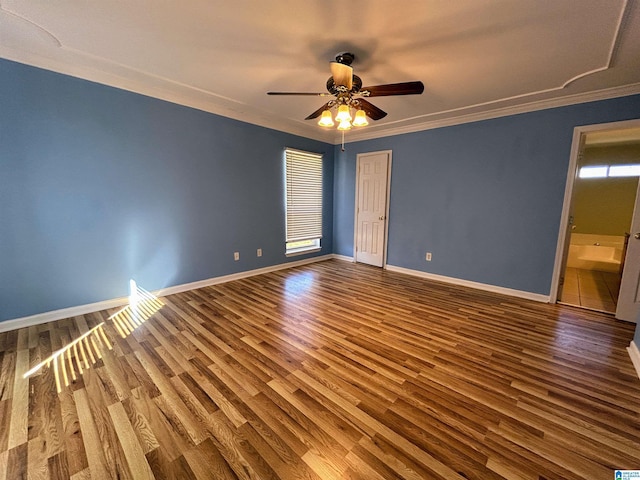 empty room featuring hardwood / wood-style floors, ornamental molding, and a healthy amount of sunlight