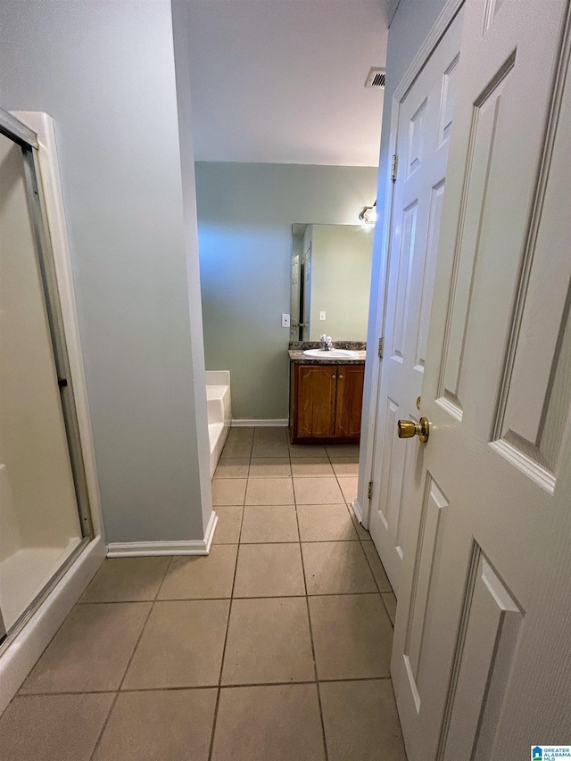 bathroom with tile patterned flooring, vanity, and a shower with shower door