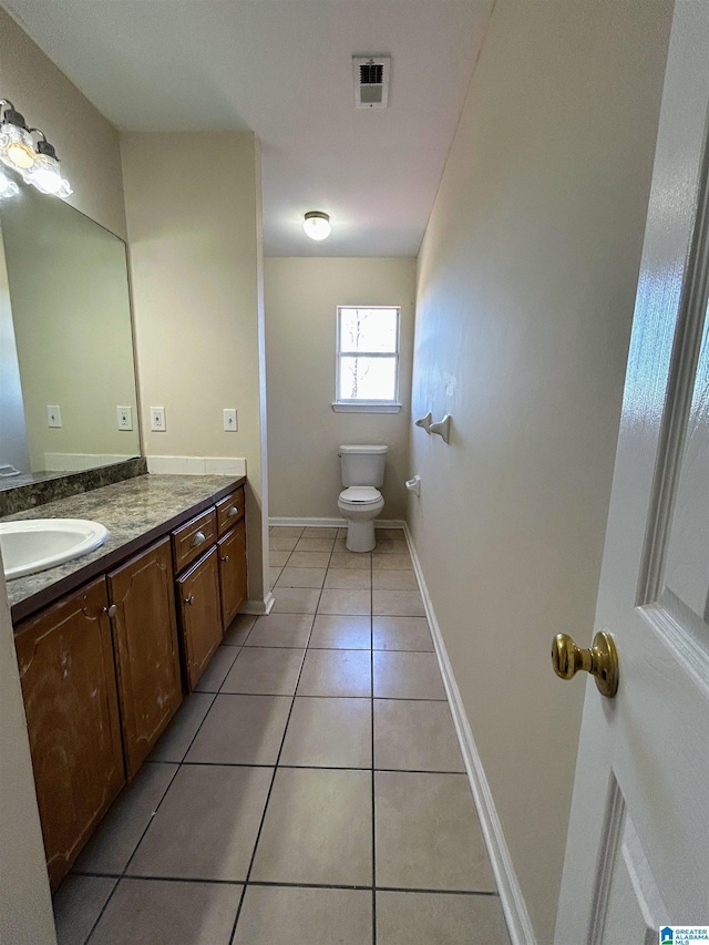 bathroom featuring tile patterned flooring, vanity, and toilet