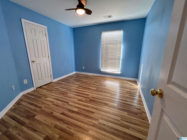 empty room featuring wood-type flooring and ceiling fan