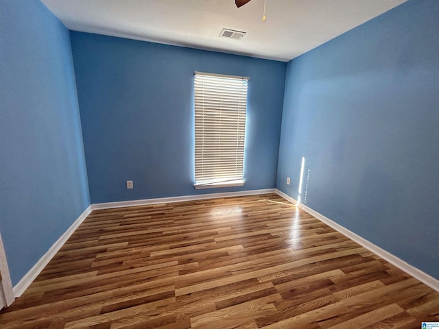 unfurnished room featuring dark wood-type flooring and ceiling fan