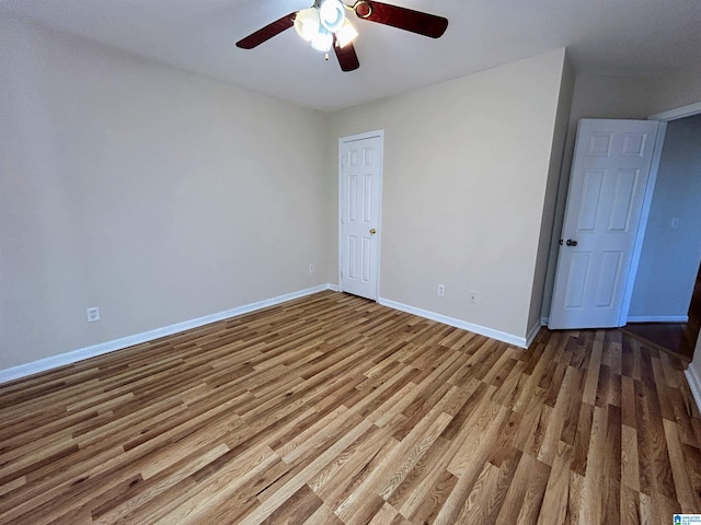 empty room with hardwood / wood-style floors and ceiling fan