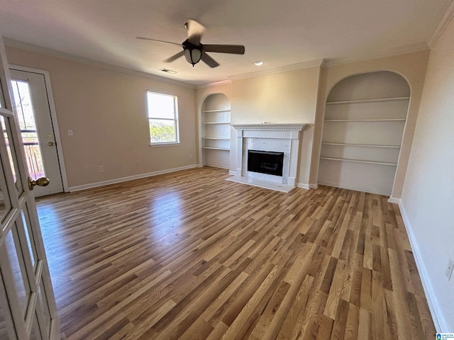 unfurnished living room with hardwood / wood-style flooring, ceiling fan, ornamental molding, and built in features