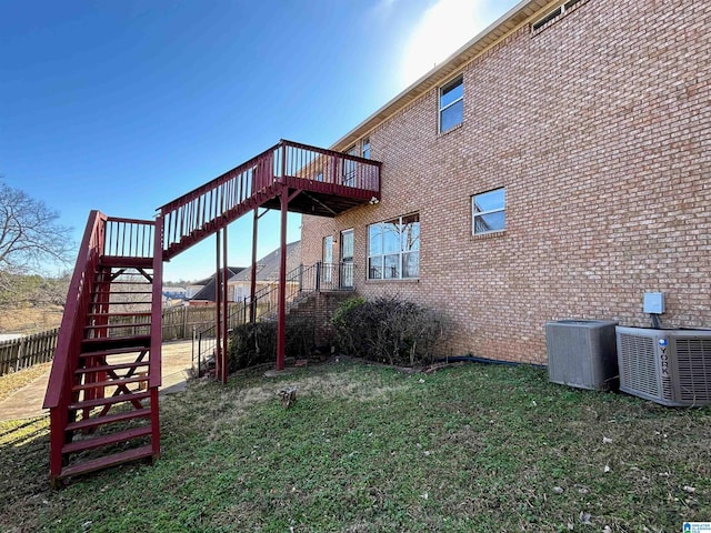 view of property exterior featuring cooling unit, a deck, and a lawn