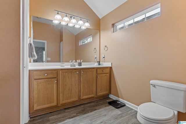 bathroom with vanity, lofted ceiling, hardwood / wood-style floors, and toilet