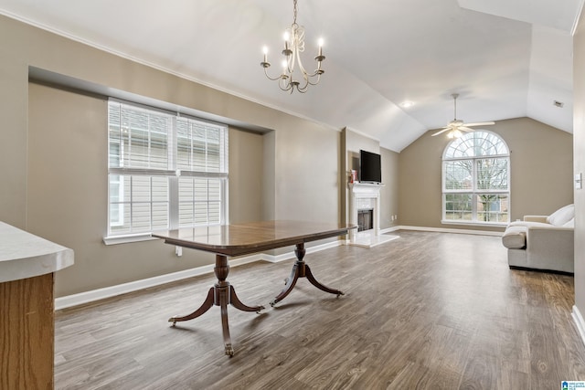 unfurnished dining area with ceiling fan with notable chandelier, wood-type flooring, and vaulted ceiling