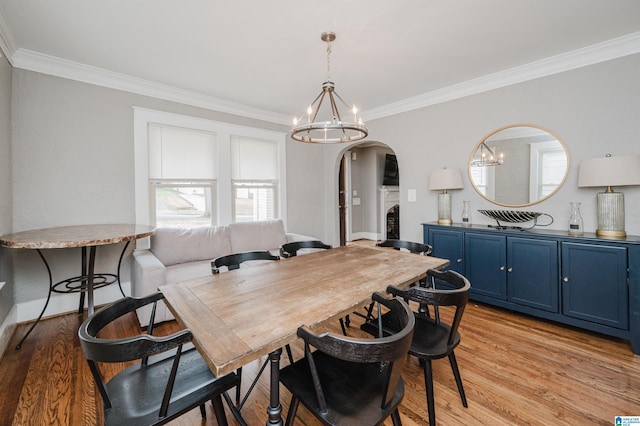 dining room featuring crown molding, a notable chandelier, and light hardwood / wood-style flooring