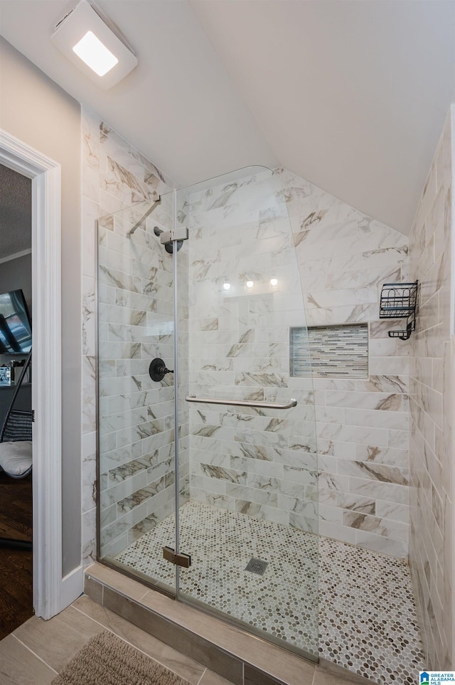 bathroom featuring vaulted ceiling and walk in shower