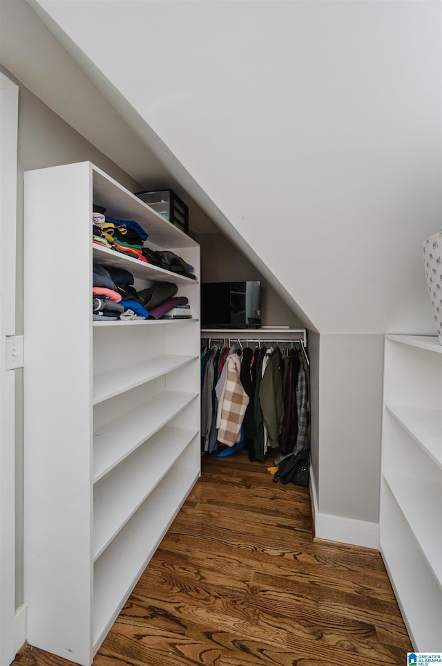 spacious closet featuring lofted ceiling and dark hardwood / wood-style floors