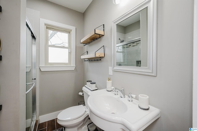 bathroom with walk in shower, toilet, and sink