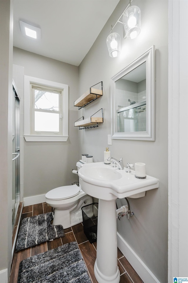 bathroom with toilet and an enclosed shower