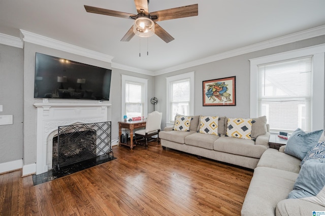 living room featuring hardwood / wood-style floors, a wealth of natural light, ornamental molding, and ceiling fan