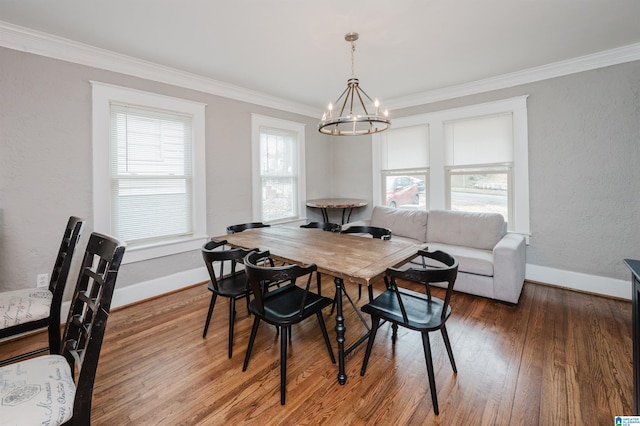 dining area with a notable chandelier, crown molding, and wood-type flooring