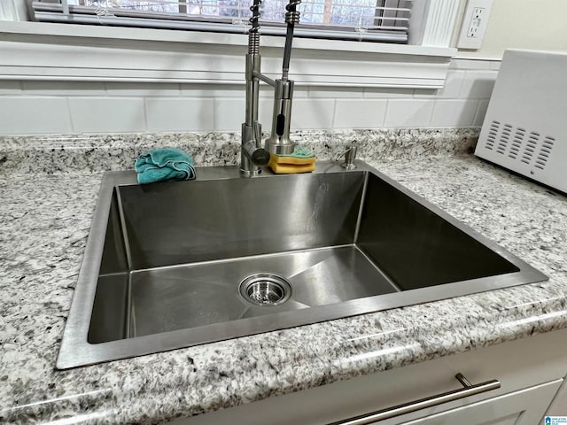 interior details with sink and decorative backsplash