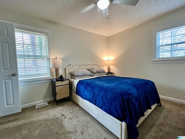 bedroom featuring ceiling fan, carpet floors, and a textured ceiling