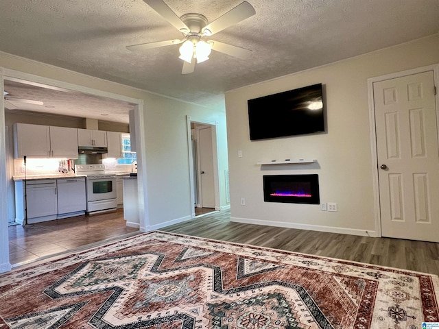 unfurnished living room with ceiling fan, hardwood / wood-style floors, and a textured ceiling