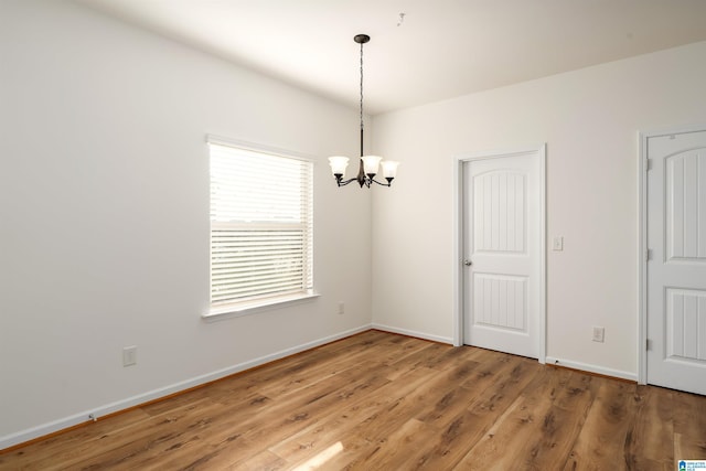 unfurnished room featuring hardwood / wood-style floors and a notable chandelier