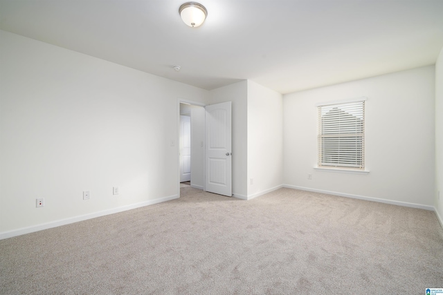 unfurnished room featuring light carpet