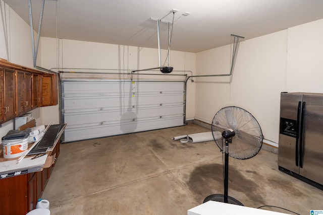 garage with a garage door opener and stainless steel fridge