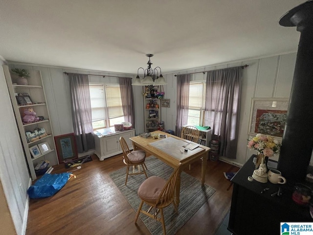 dining room featuring dark wood-type flooring, an inviting chandelier, and a wealth of natural light