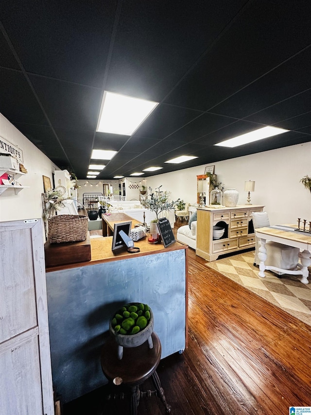 kitchen featuring hardwood / wood-style floors and a drop ceiling