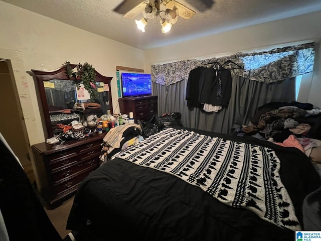 bedroom featuring ceiling fan and a textured ceiling