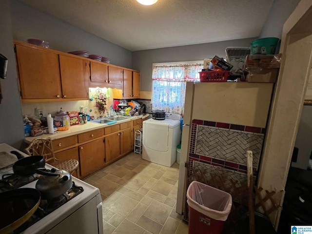 washroom with washer / clothes dryer, sink, and a textured ceiling