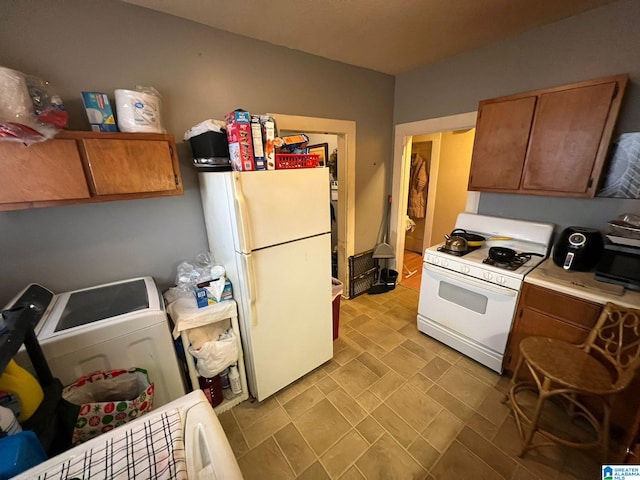 kitchen with white appliances and washer / dryer