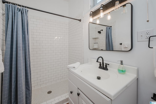 bathroom featuring walk in shower and vanity