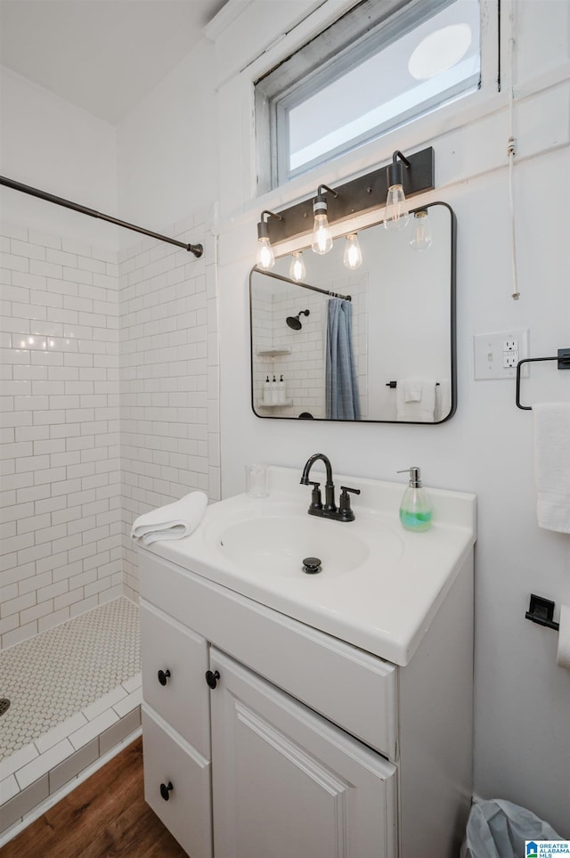 bathroom with hardwood / wood-style flooring, vanity, and curtained shower