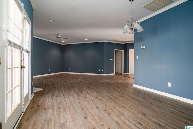 empty room with hardwood / wood-style floors, crown molding, and ceiling fan with notable chandelier