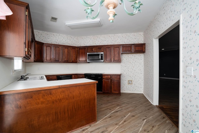 kitchen featuring sink, black appliances, kitchen peninsula, and light wood-type flooring