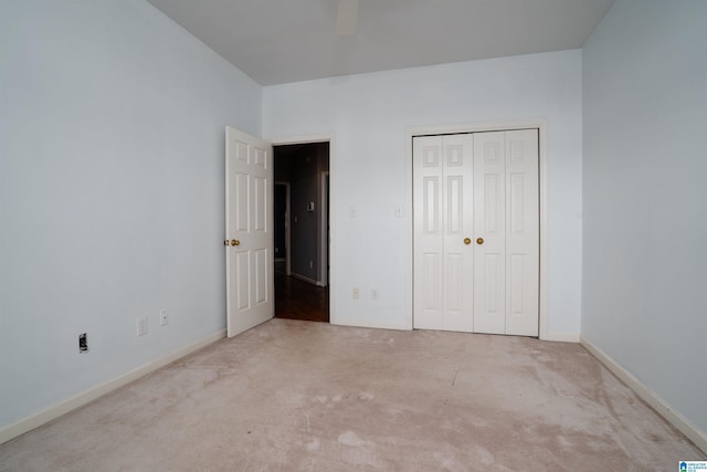 unfurnished bedroom featuring ceiling fan, a closet, and light carpet