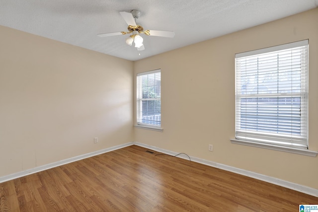 unfurnished room featuring ceiling fan, wood-type flooring, and a textured ceiling