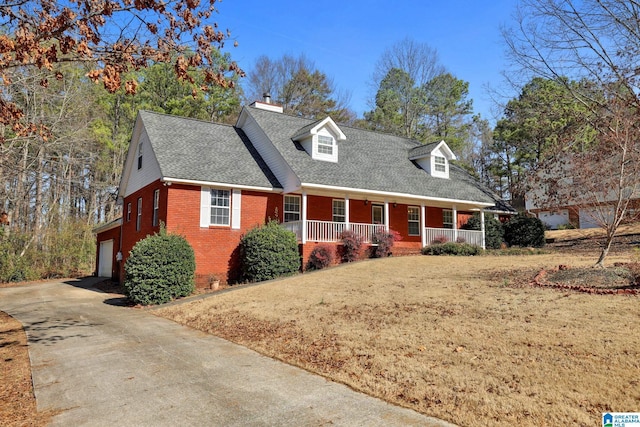 cape cod house featuring a garage, a front yard, and a porch