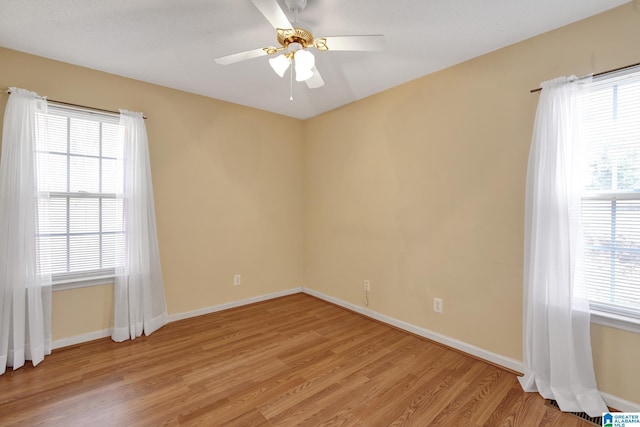 empty room with ceiling fan and light hardwood / wood-style floors