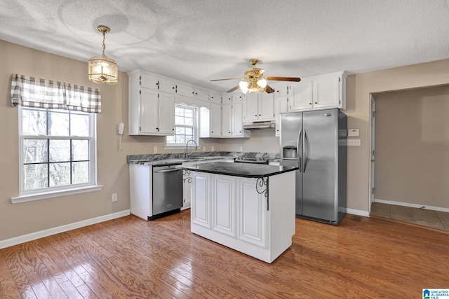 kitchen featuring a kitchen island, appliances with stainless steel finishes, and white cabinets